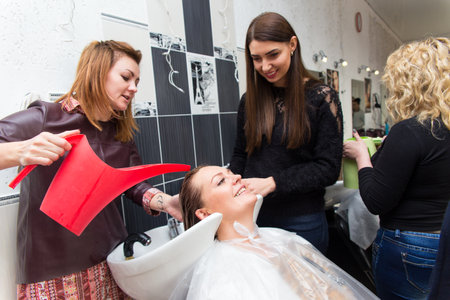 Grodno, Belarus - October 20, 2016: Participants of the seminar dye the hair of a model on advertising workshop of Keune brand in the beauty salon Kolibri.のeditorial素材