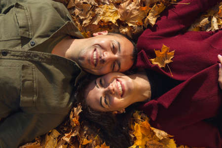 Top view of couple laying in autumn leaves. Love and happiness concept.の写真素材