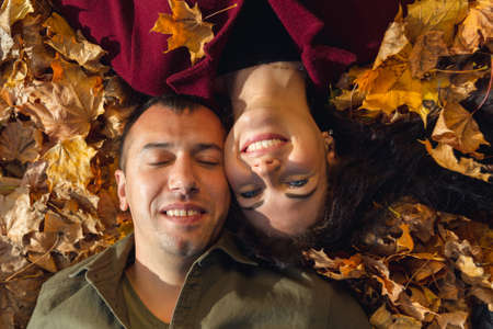 Top view of couple laying in autumn leaves. Love and happiness concept.の写真素材