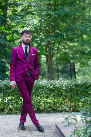 A young handsome businessman smoking on the background of the Parkの写真素材