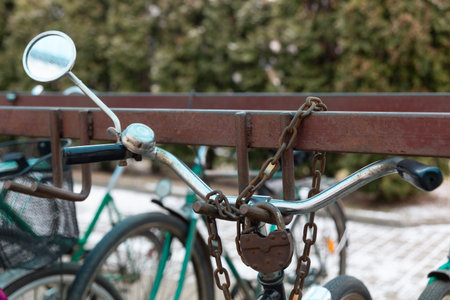 Bicycle chained to a parking. Lock and chain on bicycle handlebar . Lock a bicycle with chain and on...