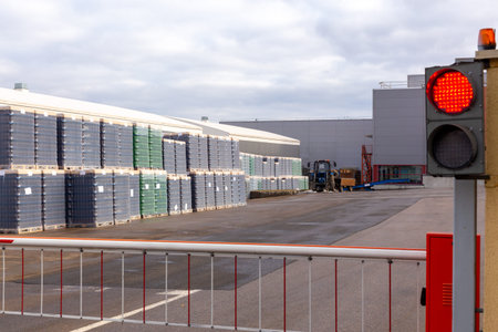 Outdoors warehouse with packages of brown and green bottles for bottling beer on the territory of the brewery. The bottles are packed on pallets and covered with plastic.の写真素材