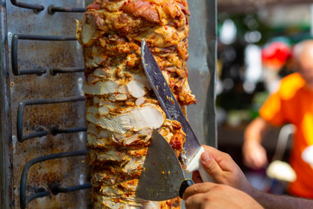 Chef cutting with doner knife Traditional Turkish Doner Kebab meat. Shawarma or gyros. Turkish, greek or middle eastern arab style chicken doner kebab food.の写真素材