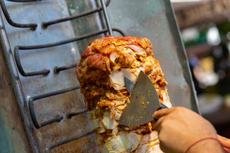 Chef cutting with doner knife Traditional Turkish Doner Kebab meat. Shawarma or gyros. Turkish, greek or middle eastern arab style chicken doner kebab food.の写真素材