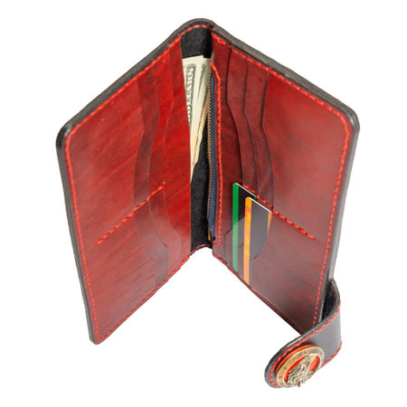Open red leather clutch with money and credit cards isolated on white background.