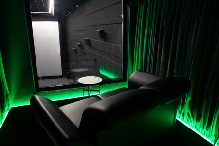 The interior of a private cinema booth in a public cinema. Comfortable VIP room with window for important guests.の写真素材