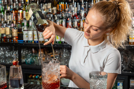 Woman bartender making an alcohol cocktail at the barの写真素材