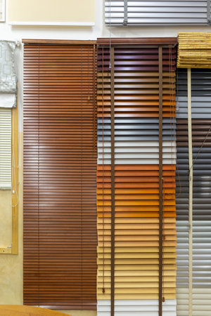Samples of blinds for windows in the store. Plastic blinds, pleated, roll-up and day-night curtains in store.の写真素材