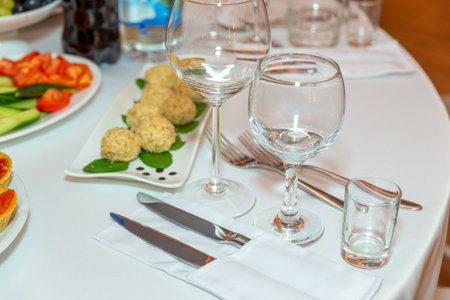 Served for holiday banquet restaurant table with dishes, snack, cutlery, wine and water glasses. European food.の写真素材