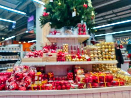 Blurred Christmas supermarket. Sale of festive Christmas accessories in a retail store. Blurred background in the store. Selective focus.の写真素材