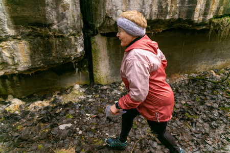 Grodno, Belarus - 25 March, 2023: Cute elderly caucasian women wearing sportswear running through a forest during exercise in outdoor orienteering Grodno Forest Day. Belarus, hobby sport.のeditorial素材