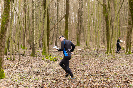Grodno, Belarus - 26 March, 2023: Strong caucasian man wearing sportswear running through a forest during exercise in outdoor orienteering Grodno Forest Day. Belarus, hobby sport.のeditorial素材