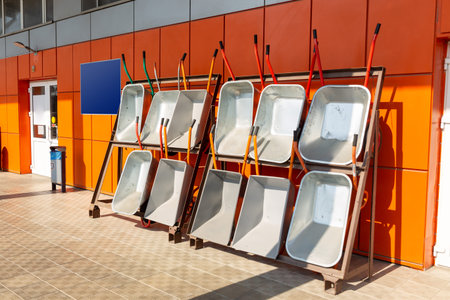 Garden wheelbarrows and tools in hardware store. Outdoor installation on the porch of the store to...