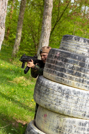 Boy weared in camouflage playing laser tag in special forest playground. Laser Tag is a command military tactical game using safe laser weapons and sensors that record hits.の写真素材