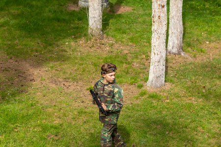 Boy weared in camouflage playing laser tag in special forest playground. Laser Tag is a command military tactical game using safe laser weapons and sensors that record hits.の写真素材