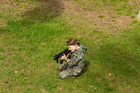 Boy weared in camouflage playing laser tag in special forest playground. Laser Tag is a command military tactical game using safe laser weapons and sensors that record hits.の写真素材