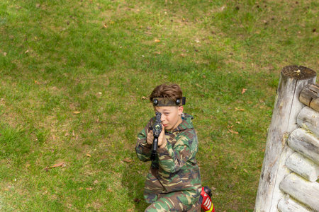 Boy weared in camouflage playing laser tag in special forest playground. Laser Tag is a command military tactical game using safe laser weapons and sensors that record hits.の写真素材