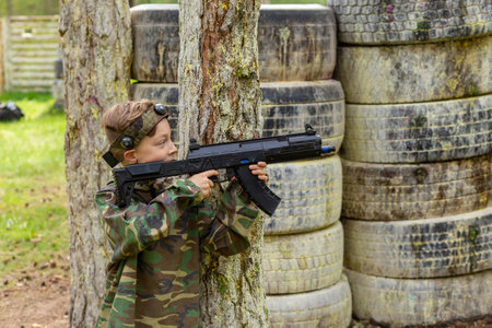 Boy weared in camouflage playing laser tag in special forest playground. Laser Tag is a command military tactical game using safe laser weapons and sensors that record hits.の写真素材