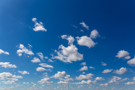 Deep blue skies with white clouds background, blue cloudy skies texture, dark blue sky wallpaper with white fully clouds and sunlight.の写真素材