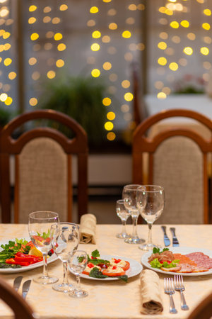 Served festive table with snacks, glasses, glasses, cutlery and napkins for a banquet on the occasion of a wedding or birthday or Christmas or other bright event in the restaurantの写真素材