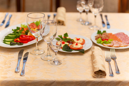 Served festive table with snacks, glasses, glasses, cutlery and napkins for a banquet on the...