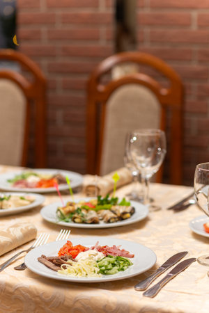 Served festive table with snacks, glasses, glasses, cutlery and napkins for a banquet on the occasion of a wedding or birthday or Christmas or other bright event in the restaurantの写真素材