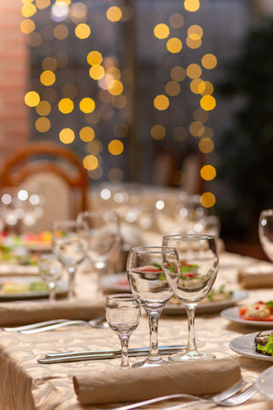 Served festive table with snacks, glasses, glasses, cutlery and napkins for a banquet on the occasion of a wedding or birthday or Christmas or other bright event in the restaurantの写真素材