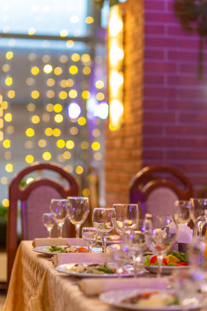 Served festive table with snacks, glasses, glasses, cutlery and napkins for a banquet on the occasion of a wedding or birthday or Christmas or other bright event in the restaurantの写真素材