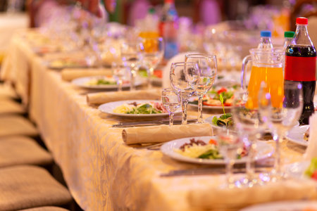 Served festive table with snacks, glasses, glasses, cutlery and napkins for a banquet on the occasion of a wedding or birthday or Christmas or other bright event in the restaurantの写真素材