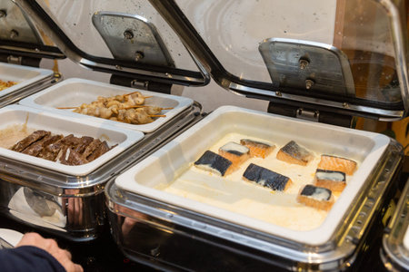 Row of open buffet food dishes at party banquet hall. Chafing Dish ready for service made of stainless steel at buffet.の写真素材