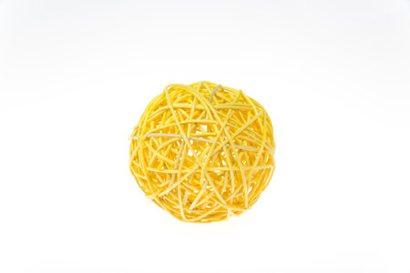 Decorative woven wicker or rattan yellow ball isolated on white.の写真素材