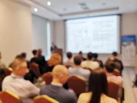 Blurred background image of audience in a business conference or seminar. Audience listens to the lecturer at the conference in auditorium.の写真素材