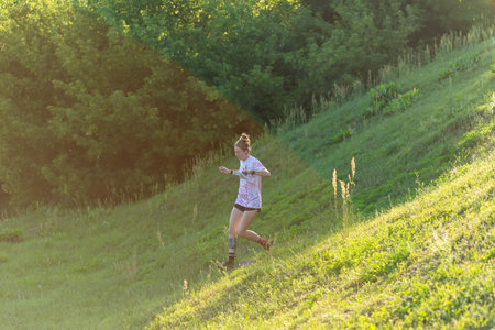 Grodno, Belarus - 26 June, 2024: Cute young caucasian women wearing sportswear running through a forest during exercise in outdoor orienteering Street-O. The map in her hands. Hobby sport.のeditorial素材