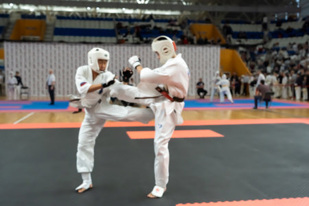 Blurred defocused image with two karate practitioners sparring on a tatami mat. Karate players competing during the matchの写真素材