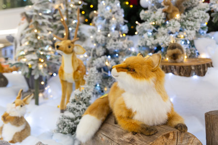 A Christmas installation with Santa and forest animals at the foot of a festively decorated Christmas tree in the big shopping mall. Selective focus.の写真素材