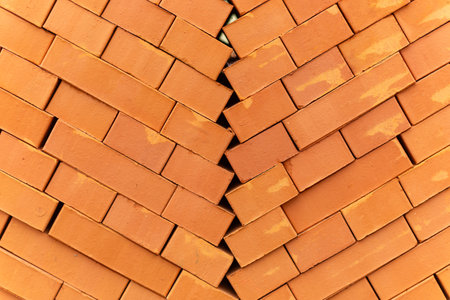 Stacks of new, red ceramic brick stacked on wooden pallets. Lots of new orange build bricks wall background and texture. Real estate construction, renovations. Selective focus.の写真素材