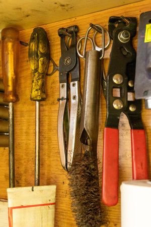 A well-organized wooden rack displays essential tools for car repair in an auto repair shop, showcasing a professional workspace that embodies efficiency and craftsmanship.の写真素材