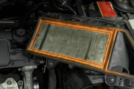 Old used air filter in dirt and dust to clean the air. Dirty car engine air filter to be replaced due to contamination.の写真素材