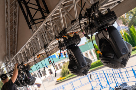 Installation of lighting equipment on a mobile concert stage. A worker installs spotlights under a canopy of a metal structure. unrecognizable personの写真素材