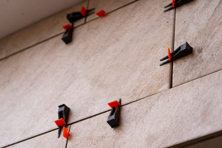 Tile leveling system with plastic clips and wedges, shot while the tile mortar sets. Wall tiling.の写真素材