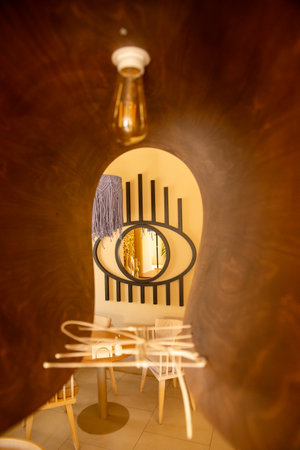 The inviting interior of a coffee shop adorned with warm colors and cozy upholstered furniture, creating a perfect atmosphere for relaxation and coffee enjoyment.の写真素材