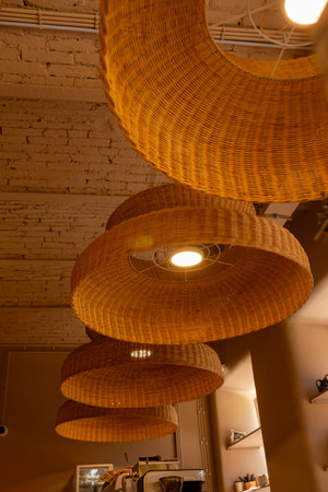 Handmade wicker rattan chandelier hanging at cafeteria in beautiful morning light. Rattan lantern lamps.の写真素材
