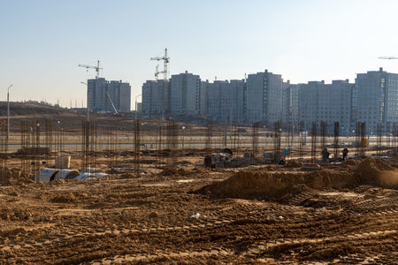 Brigade of builders knit fittings for pouring concrete. Workers installing binding wires to...