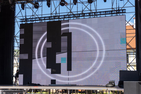 A large modular LED screen displays vibrant video footage during an energetic outdoor concert, illuminating the night with dynamic visuals.の写真素材