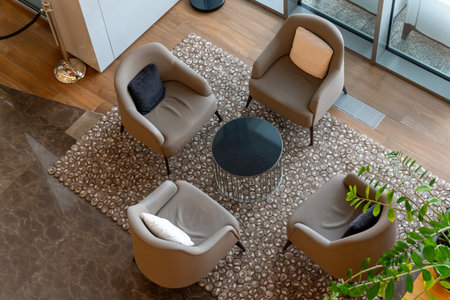 A modern hotel lobby with four plush armchairs and a meeting table, captured in a minimalist...