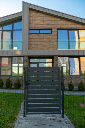 Modern townhouse with a secure gate and fence, showcasing suburban privacy and contemporary residential architecture.の写真素材