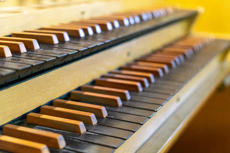 Antique organ keyboard and controls in a Lutheran church. Sheet music with notes rests on the stand.の写真素材