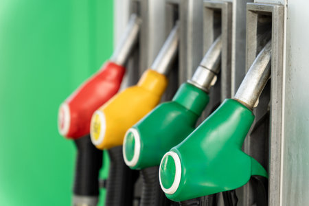 Close-up of four fuel dispensing nozzles on a gas pump, ready for refueling. A detailed view of modern petrol station equipment.の写真素材