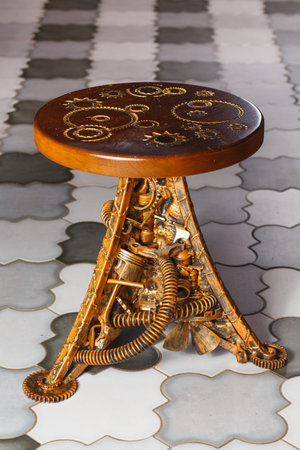 A round steampunk and technopunk style barstool made of metal and wood, with gears and industrial...
