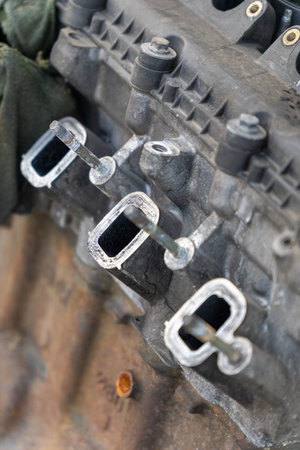 Car engine intake manifold during repair service in auto workshop garage.
